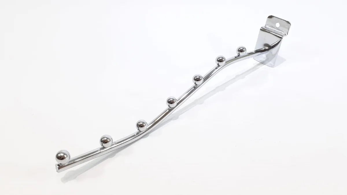 Perchero cromado con seis ganchos redondeados, montado en blanco.