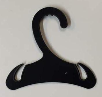 Percha de ropa de plástico negra sobre fondo blanco, con gancho y recortes en los hombros.