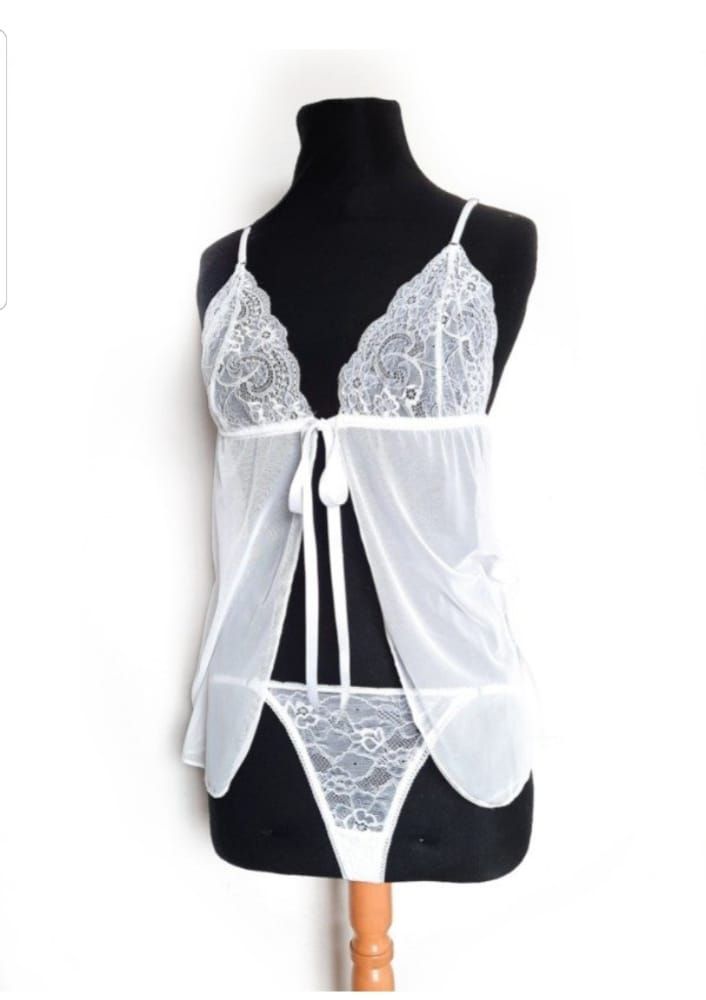 Conjunto de lencería blanca sobre maniquí negro, con top de encaje, capa transparente y tanga.