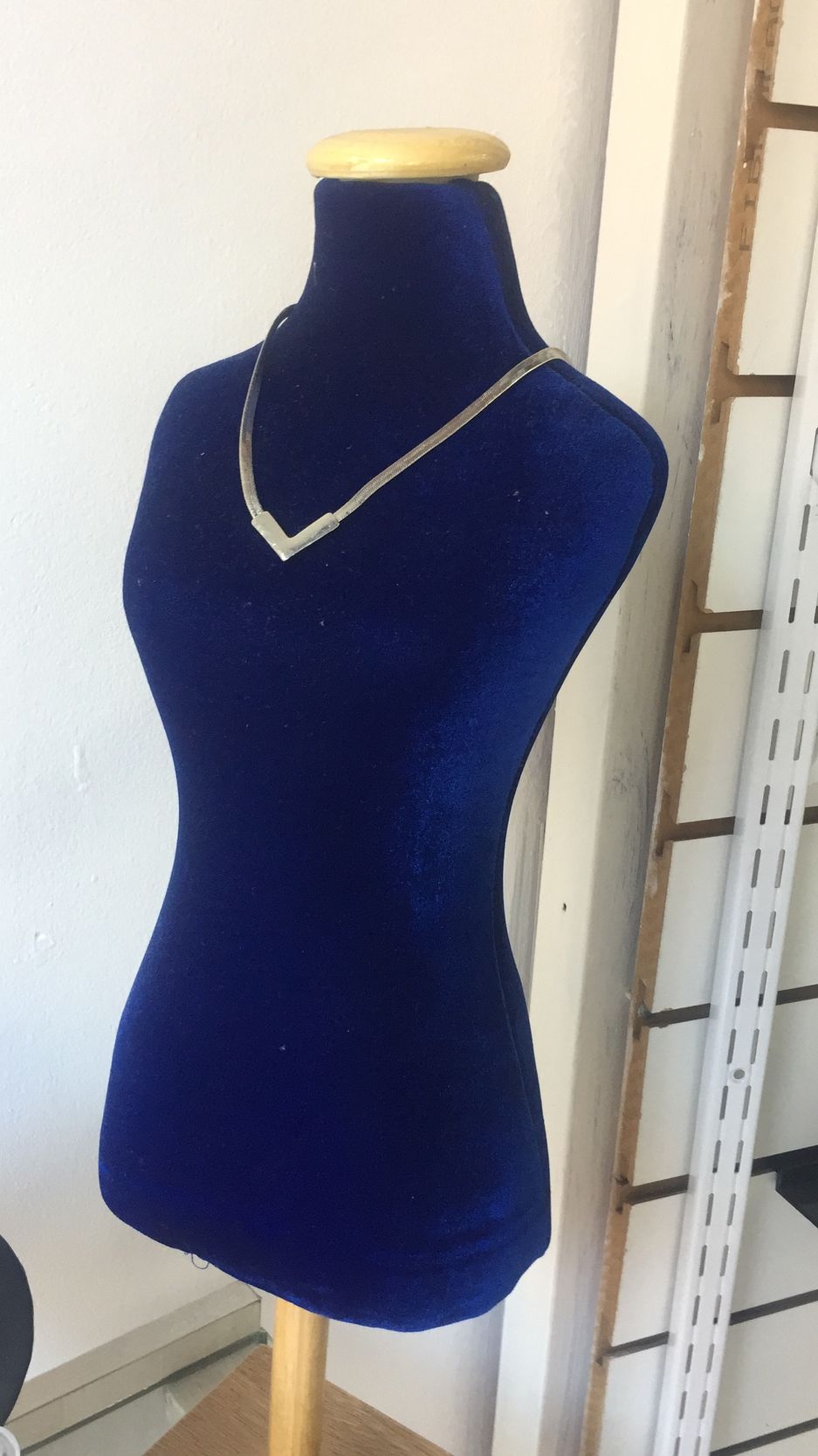 Expositor de collar de terciopelo azul con collar de plata.