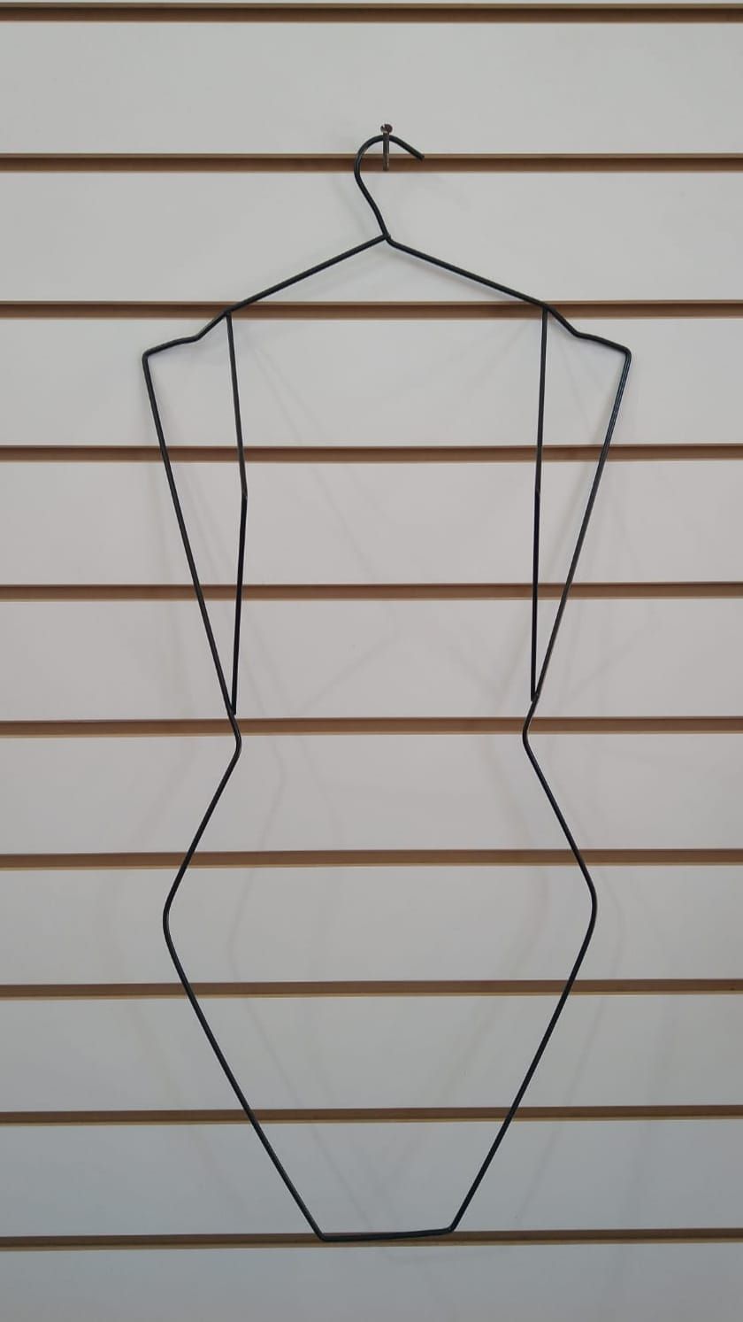 Percha de alambre para maniquí sobre una pared con listones blancos y marrones.