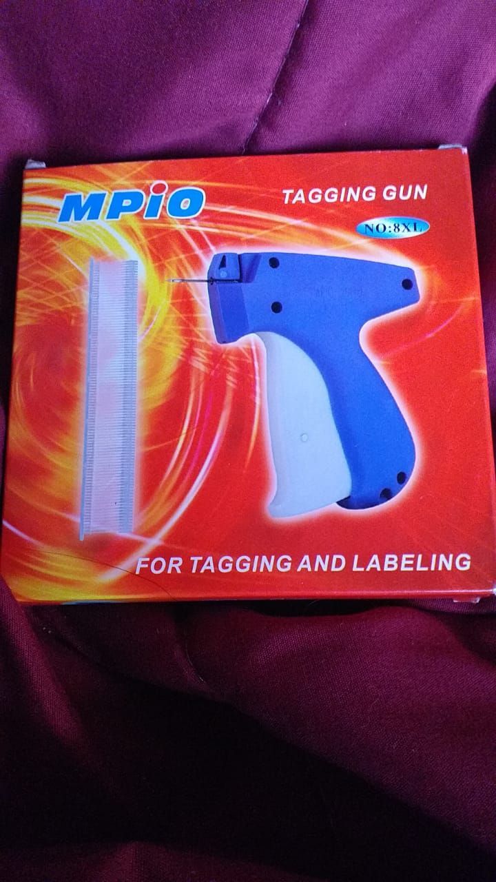 Pistola etiquetadora azul y blanca en caja, con etiquetas y texto 