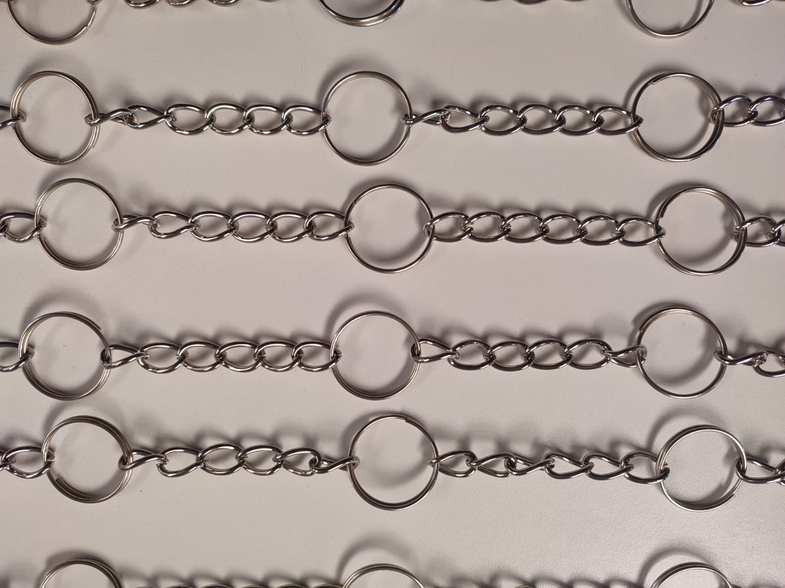 Filas de eslabones de cadena de plata con conectores circulares grandes.