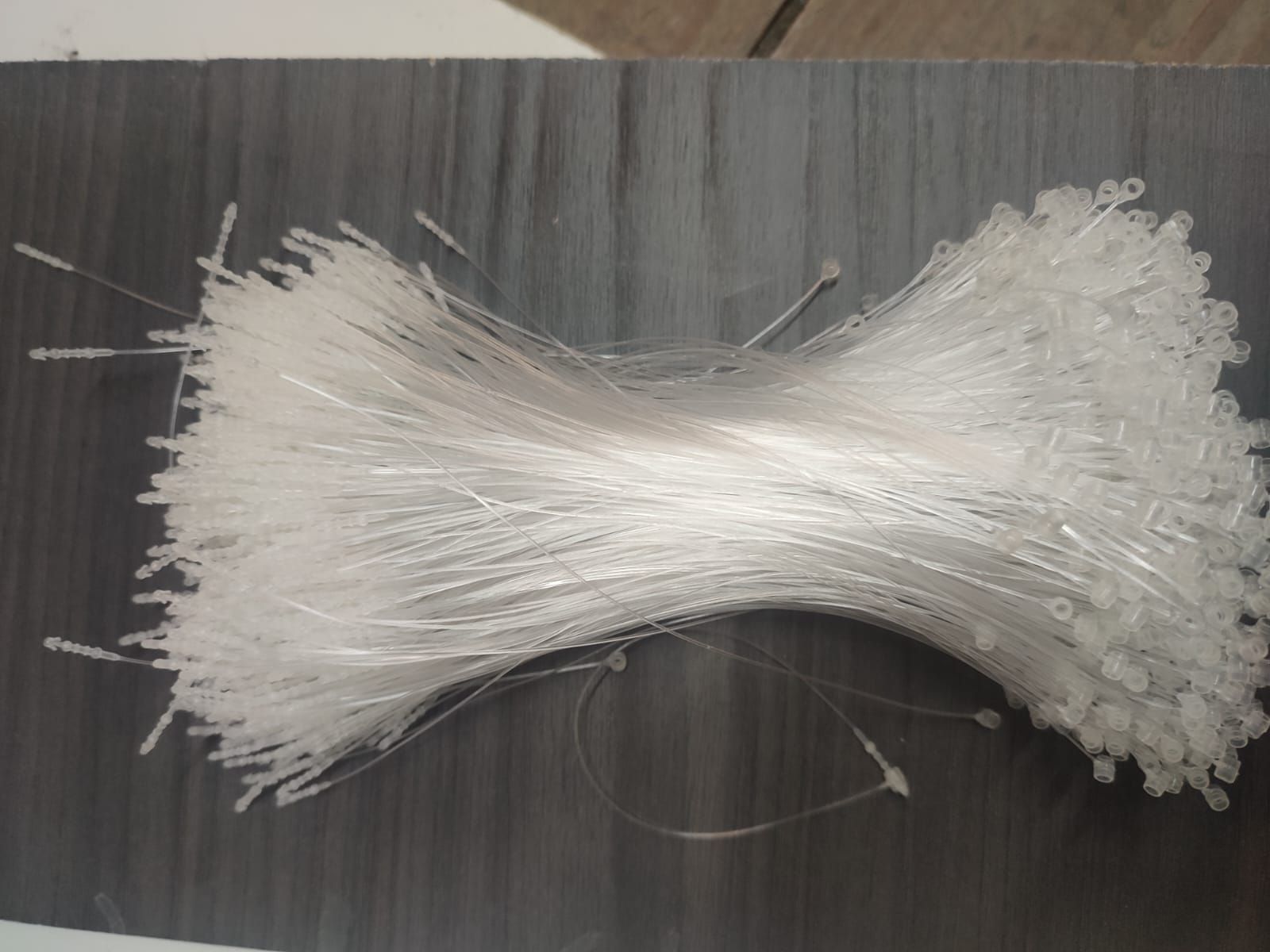 Paquete de cierres de etiquetas de plástico transparente sobre una superficie oscura.