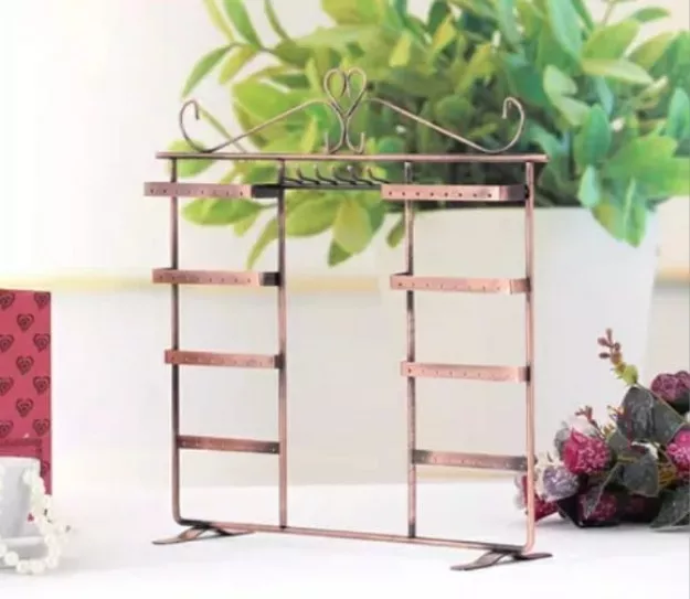 Organizador de joyas de color cobre con múltiples estantes y orificios para aretes