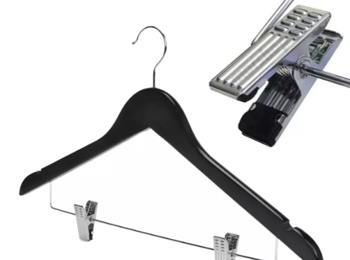 Percha de madera negra con pinzas plateadas, primer plano de una pinza.