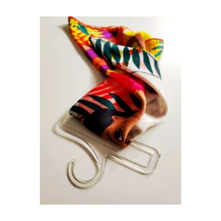 Una colorida bufanda de seda floral colgada en una percha de plástico transparente sobre un fondo blanco.