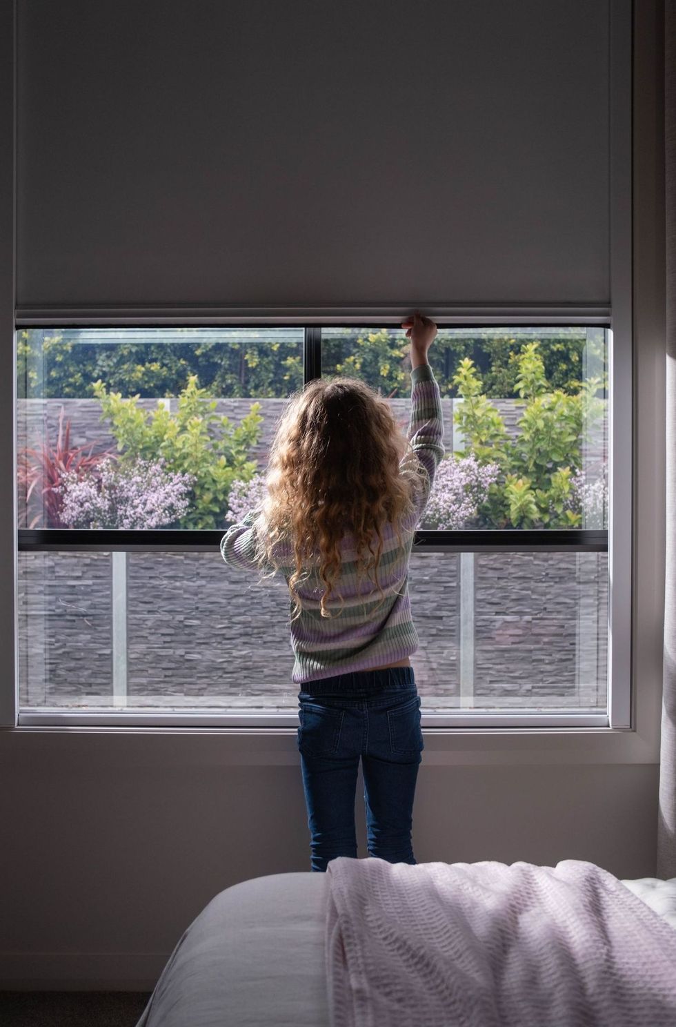 Girl lowering blackout blinds