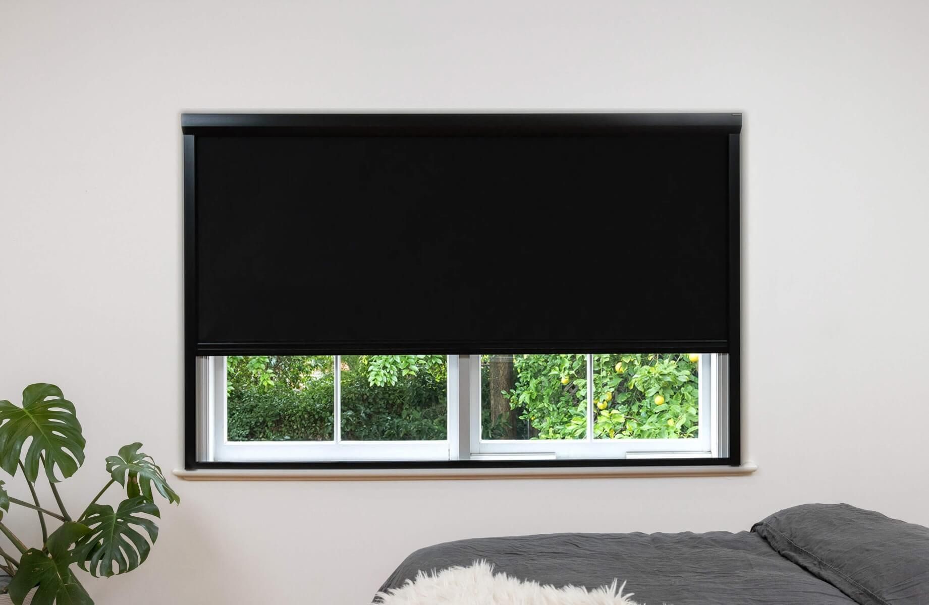 Black frame and black fabric full blackout blinds installed on a wide window, outside installation.