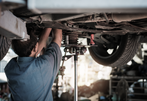 Technician at work under vehicle in garage | Automotive Repair Specialists
