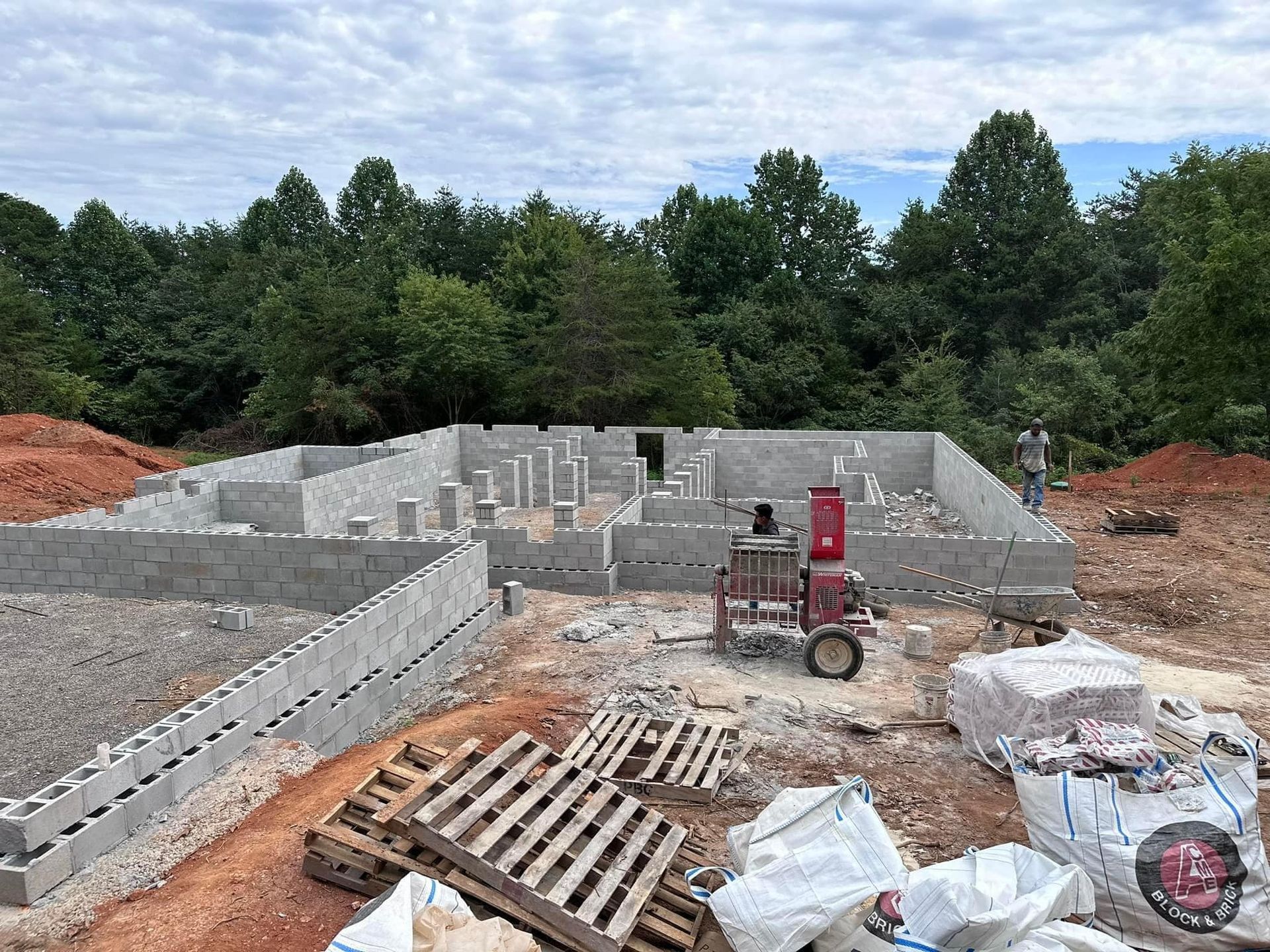 A tractor is parked in front of a building under construction.