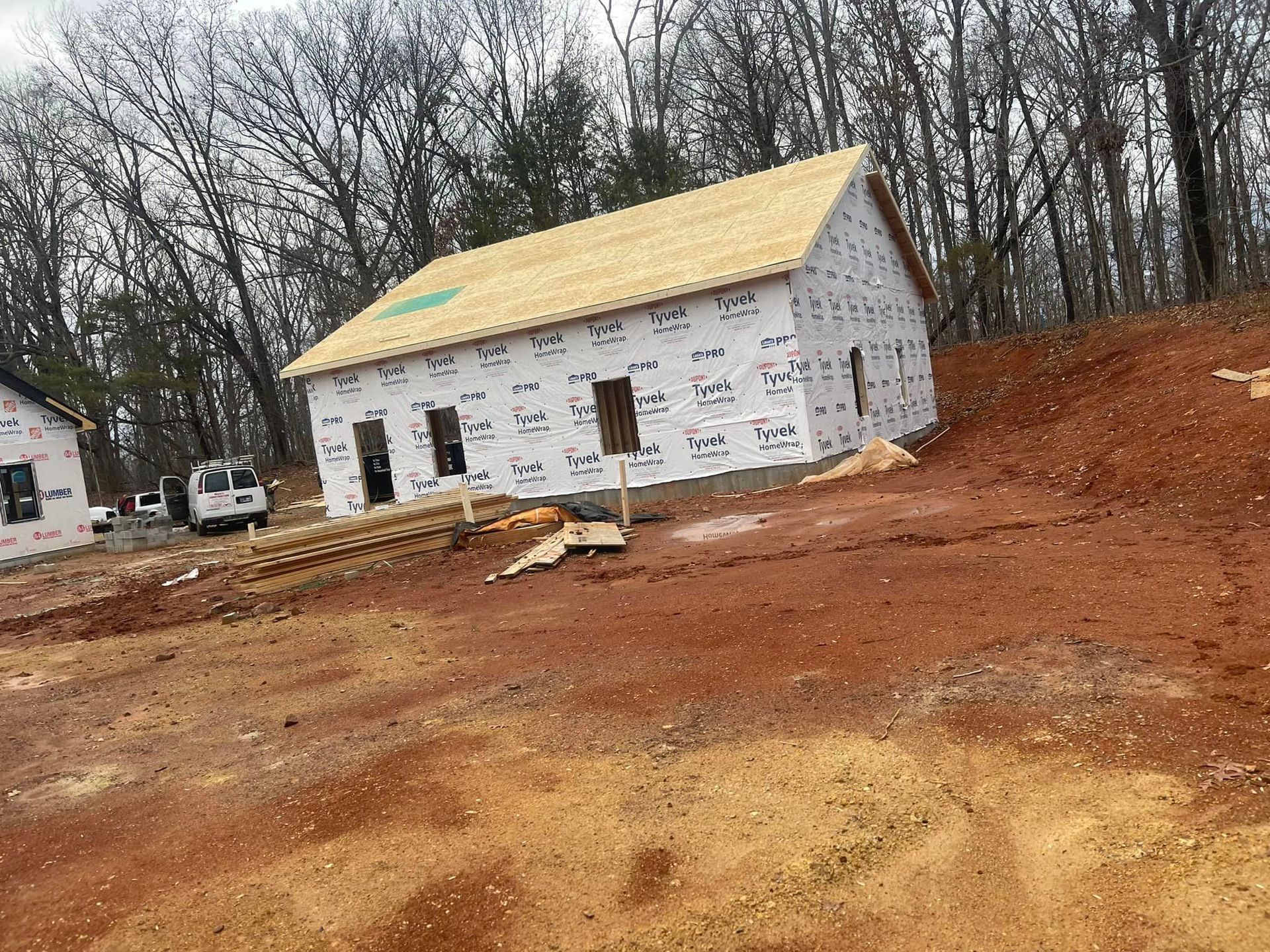 A house is being built in the middle of a dirt field.