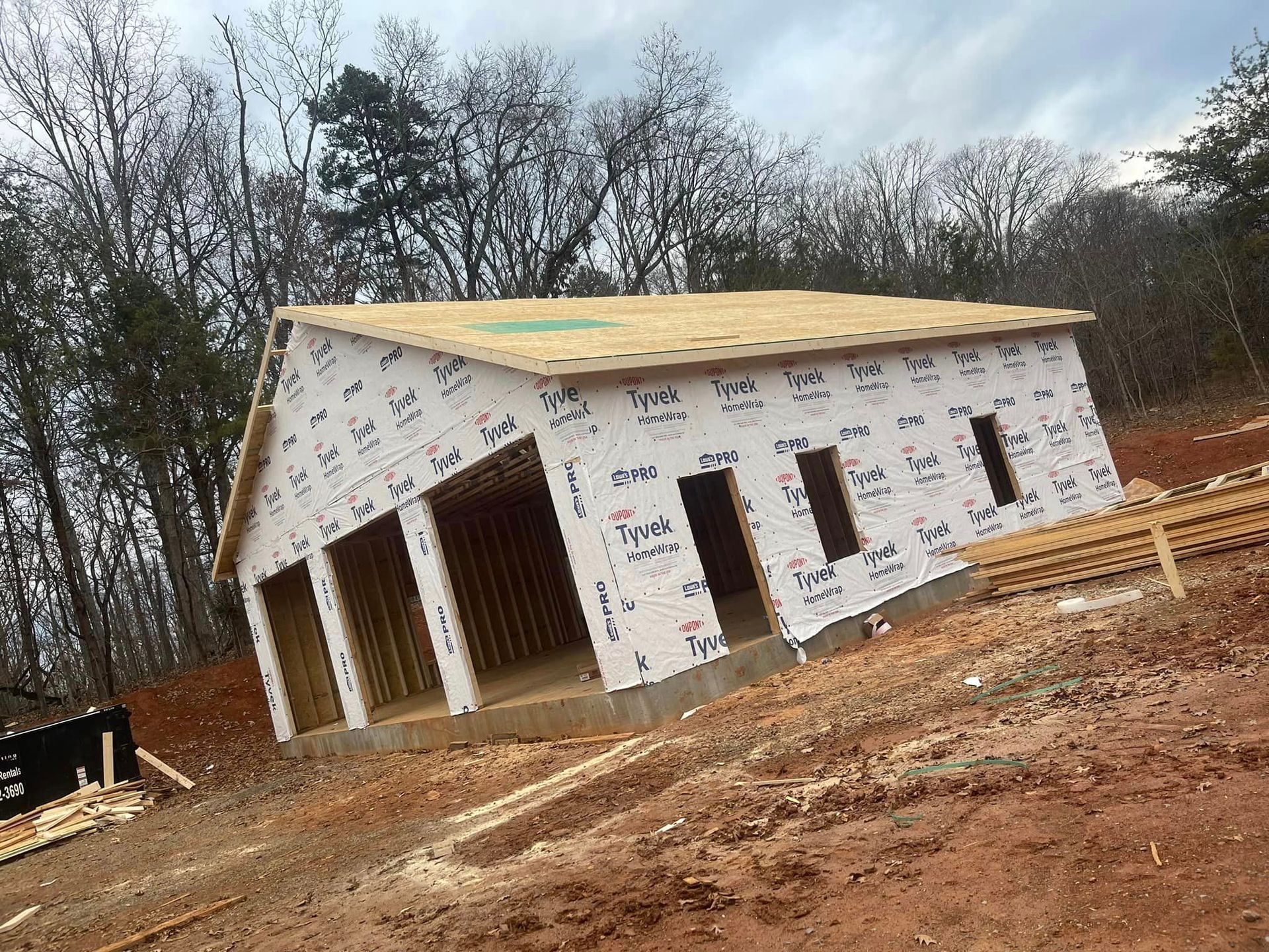 A house is being built in the middle of a dirt field.