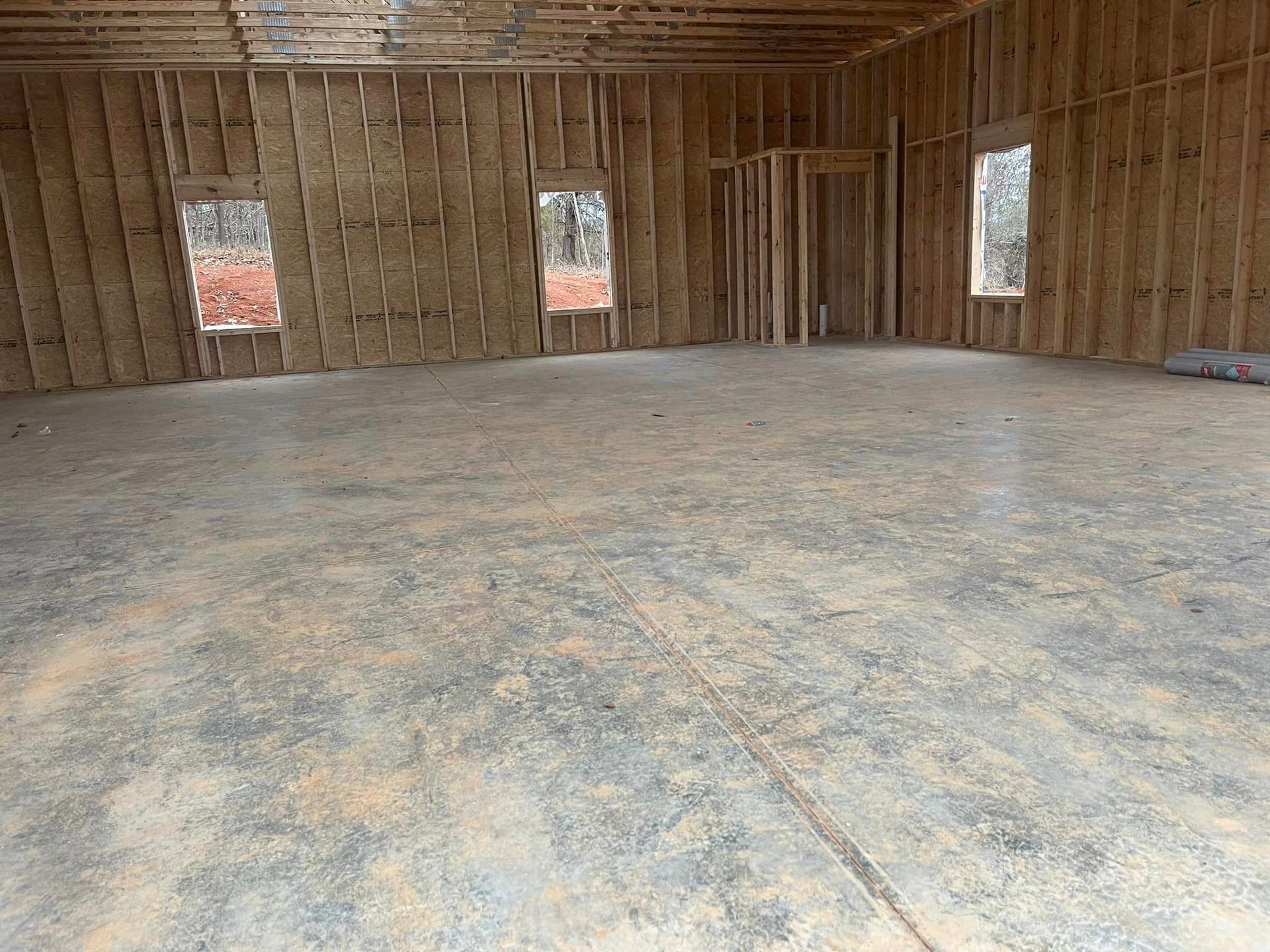 An empty room with a concrete floor and wooden walls
