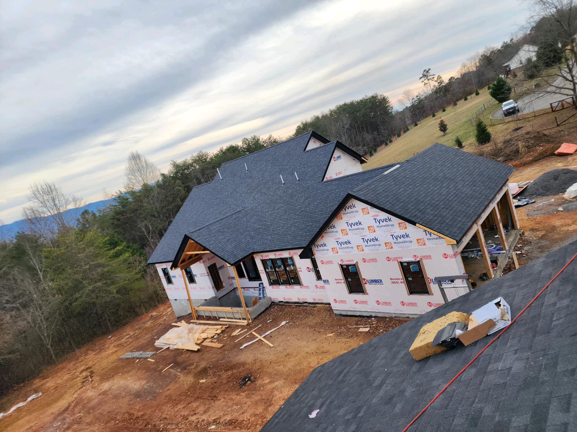 An aerial view of a house under construction with a black roof.