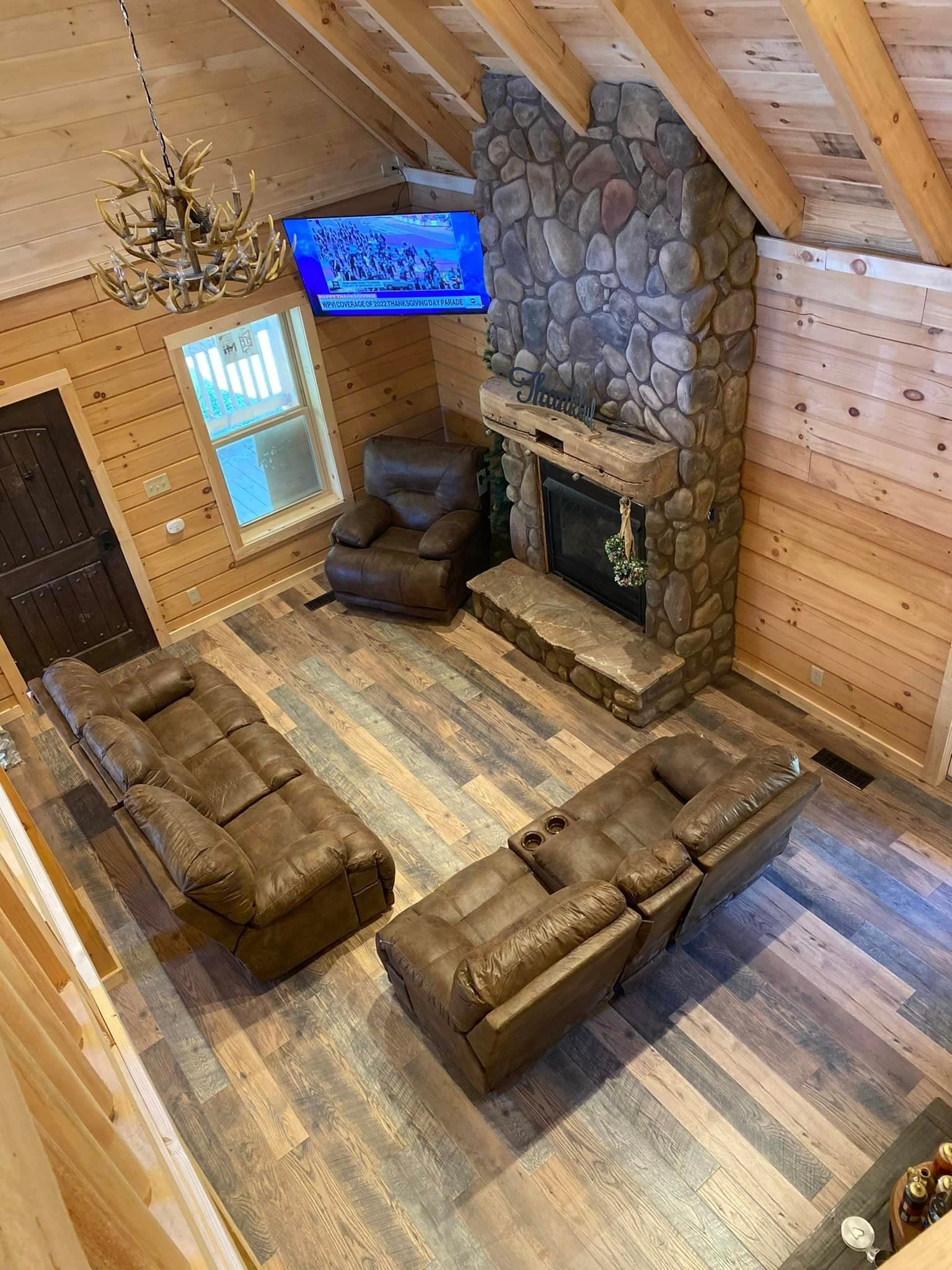 An aerial view of a living room with a fireplace and a flat screen tv.
