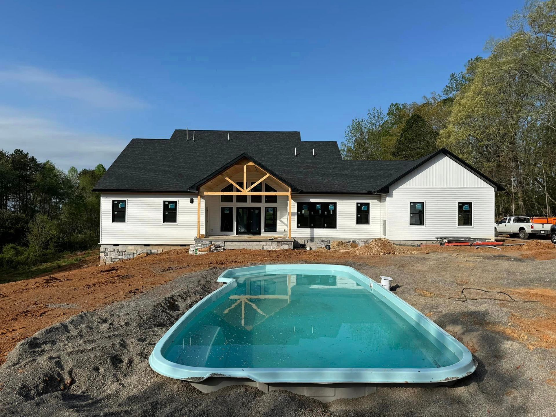 A large white house with a swimming pool in front of it.