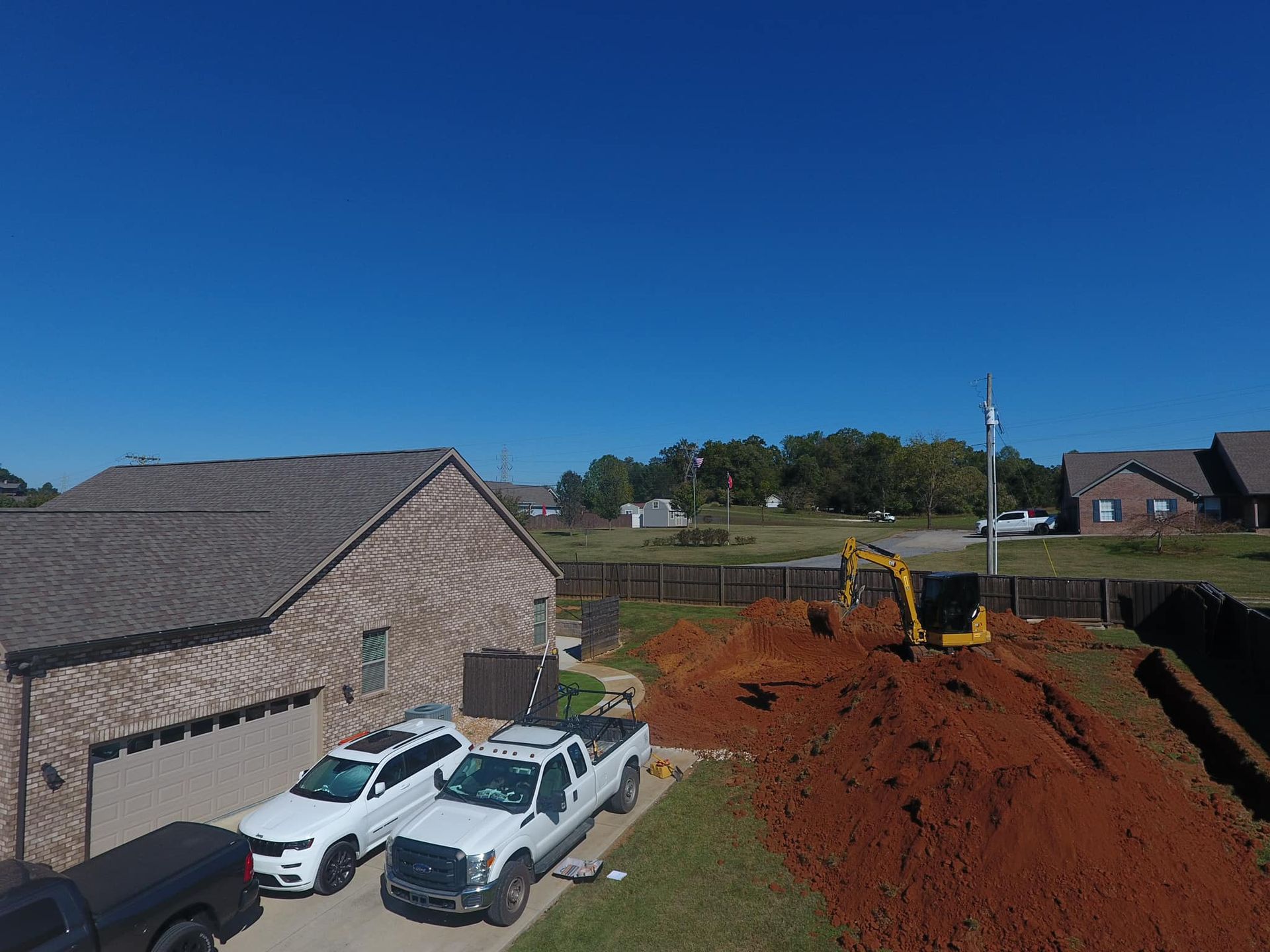An aerial view of a construction site in front of a house.