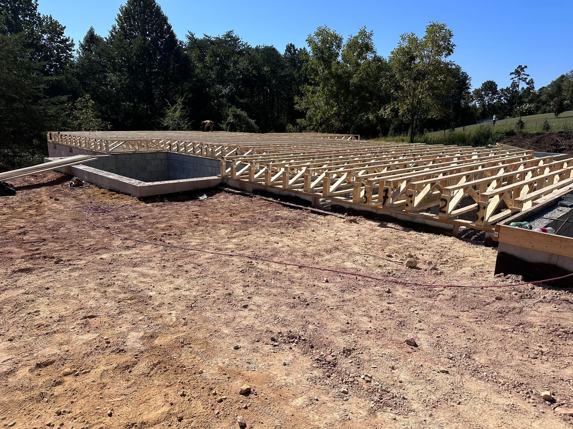A concrete foundation is being built in a dirt field