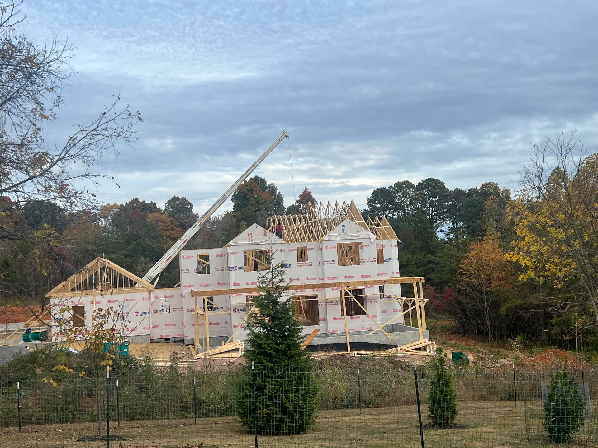 A large house is being built with a crane in the foreground.