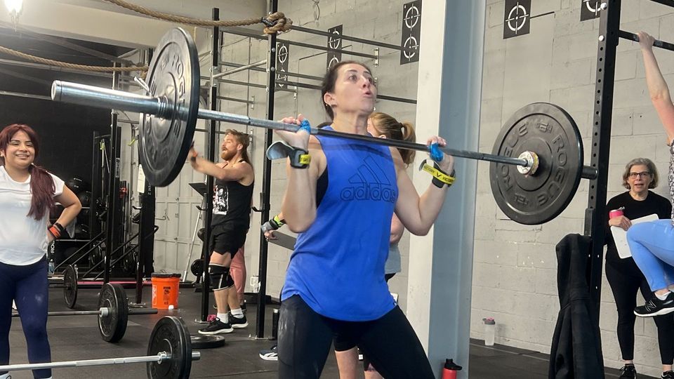 A woman performing a lift in the gym.