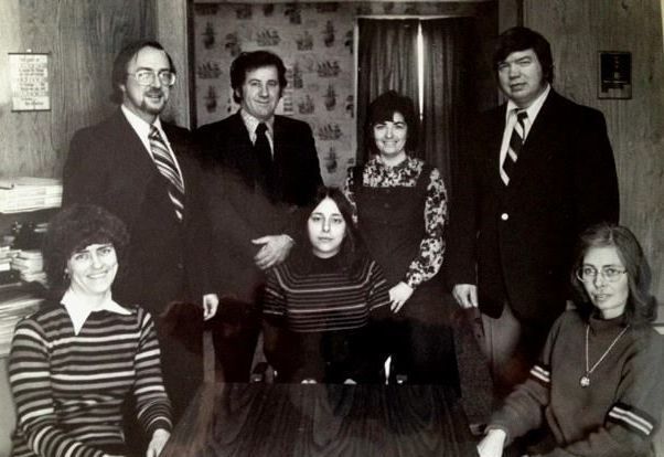 A black and white photo of a group of people posing for a picture