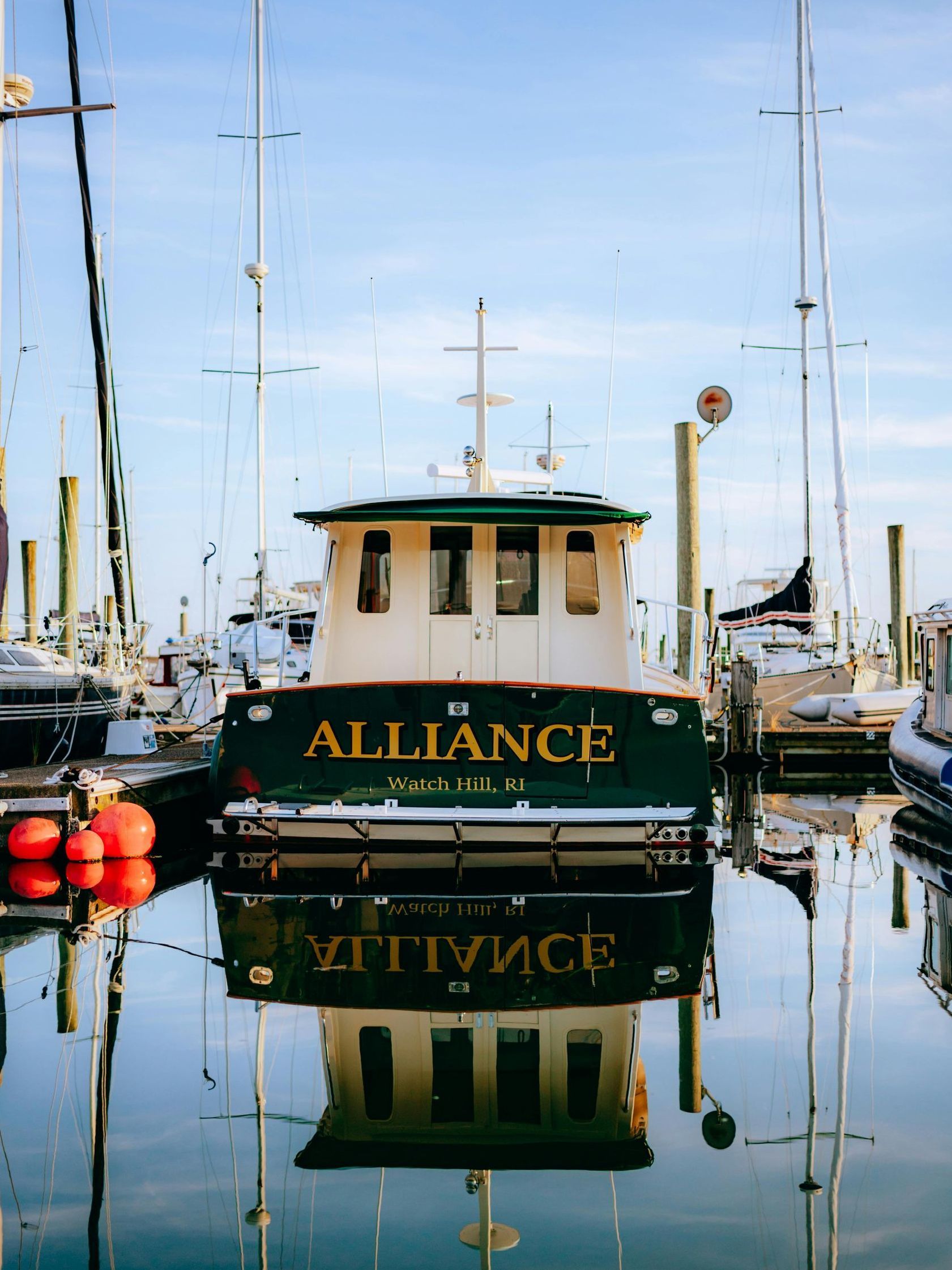 A boat called alliance is docked in a harbor