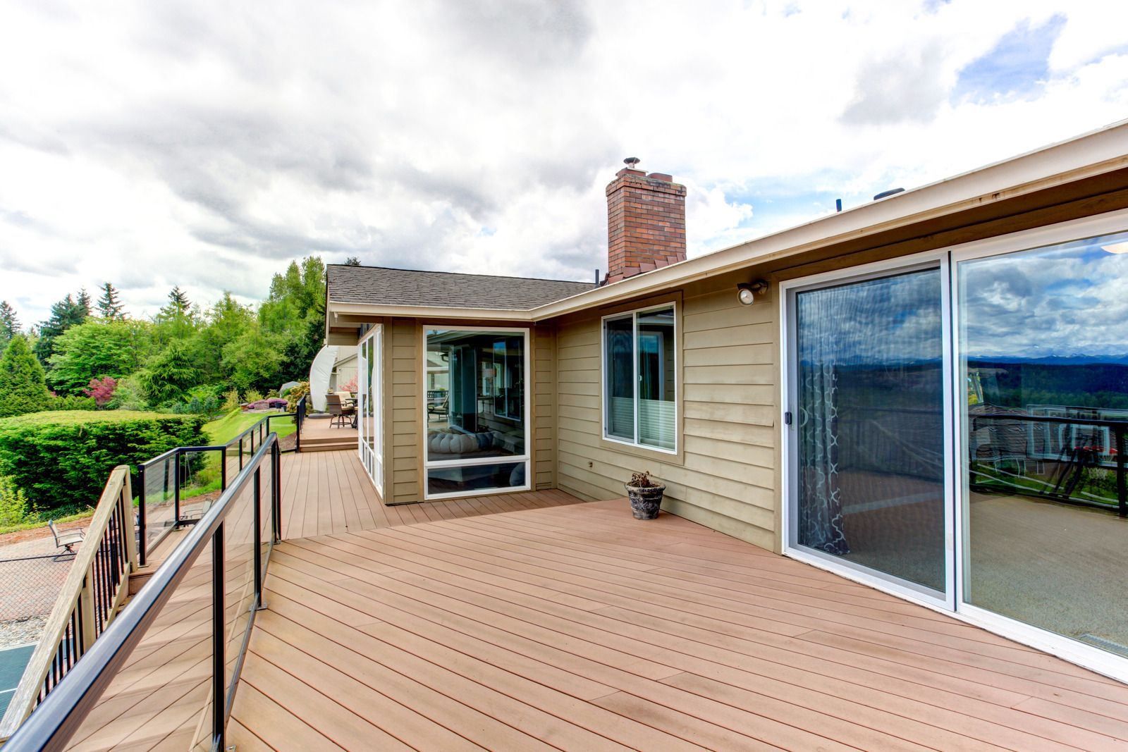 There is a large deck with sliding glass doors leading to the back of the house.