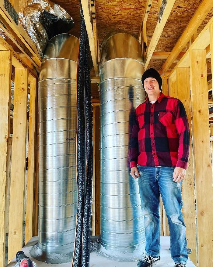 A man in a plaid shirt is standing in a building under construction.