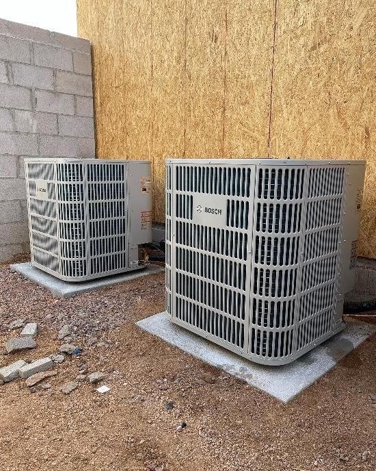 Two air conditioners are sitting next to each other outside of a building.