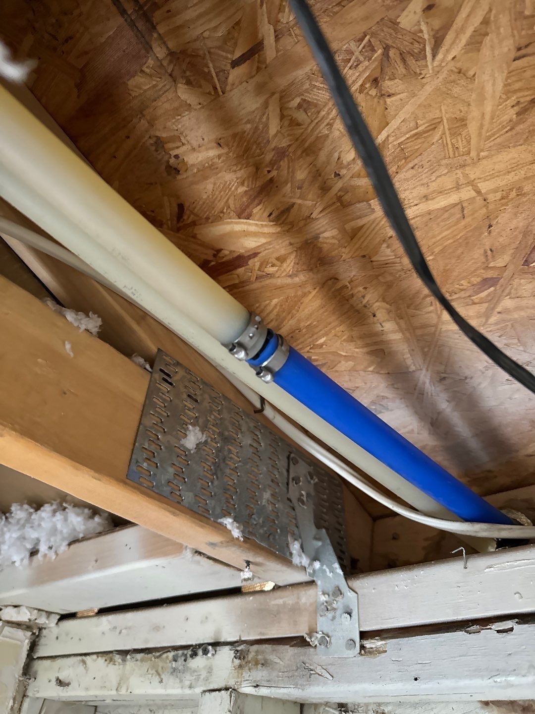 A blue pipe is hanging from the ceiling of a room.