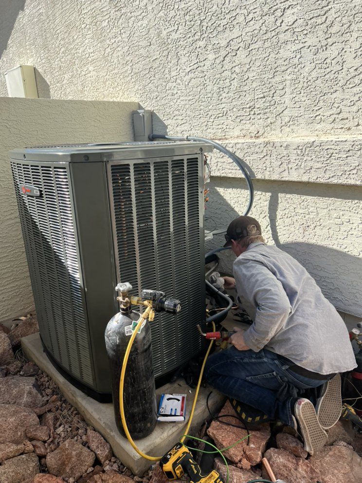 A man is working on an air conditioner outside of a building.
