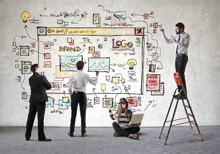 A group of people are working on a project on a whiteboard