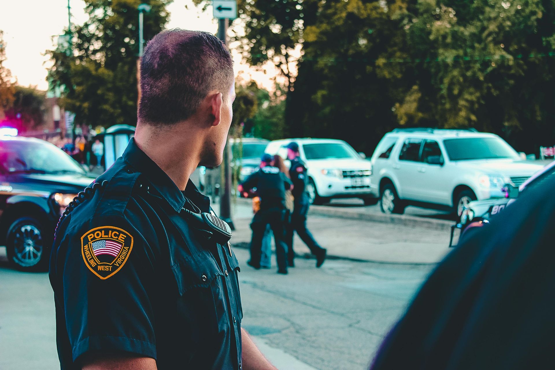 A police officer is standing in front of a crowd of people.