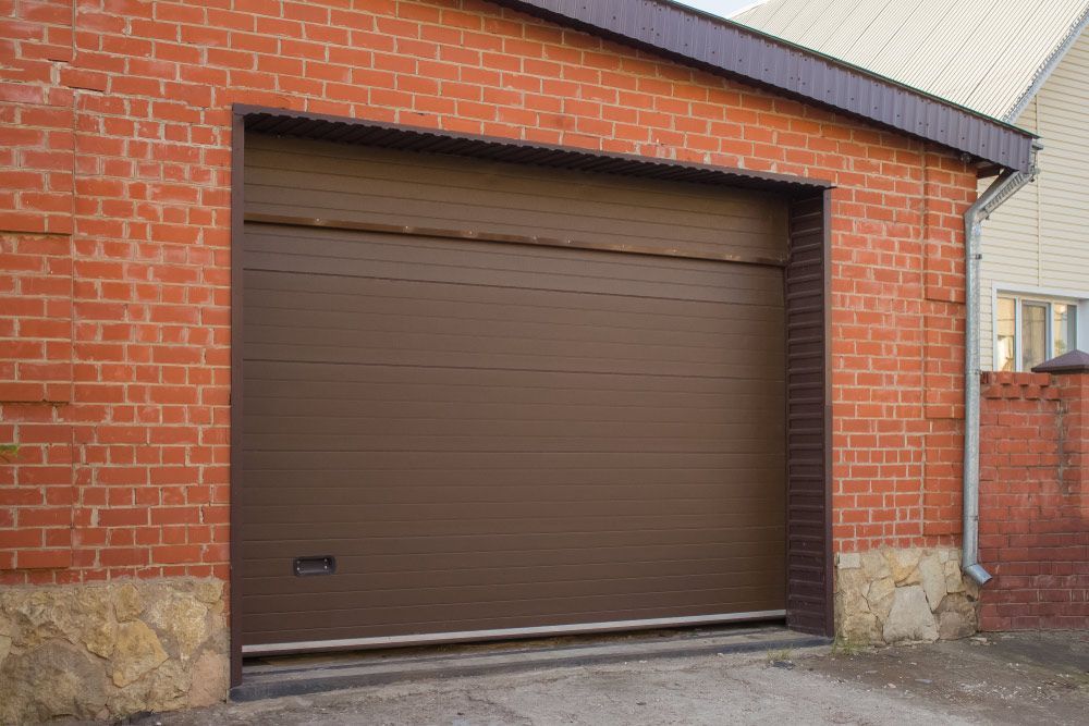 A Brown Garage Door is Sitting in Front of a Brick Building — Hastings Garage Door Services in Port Macquarie