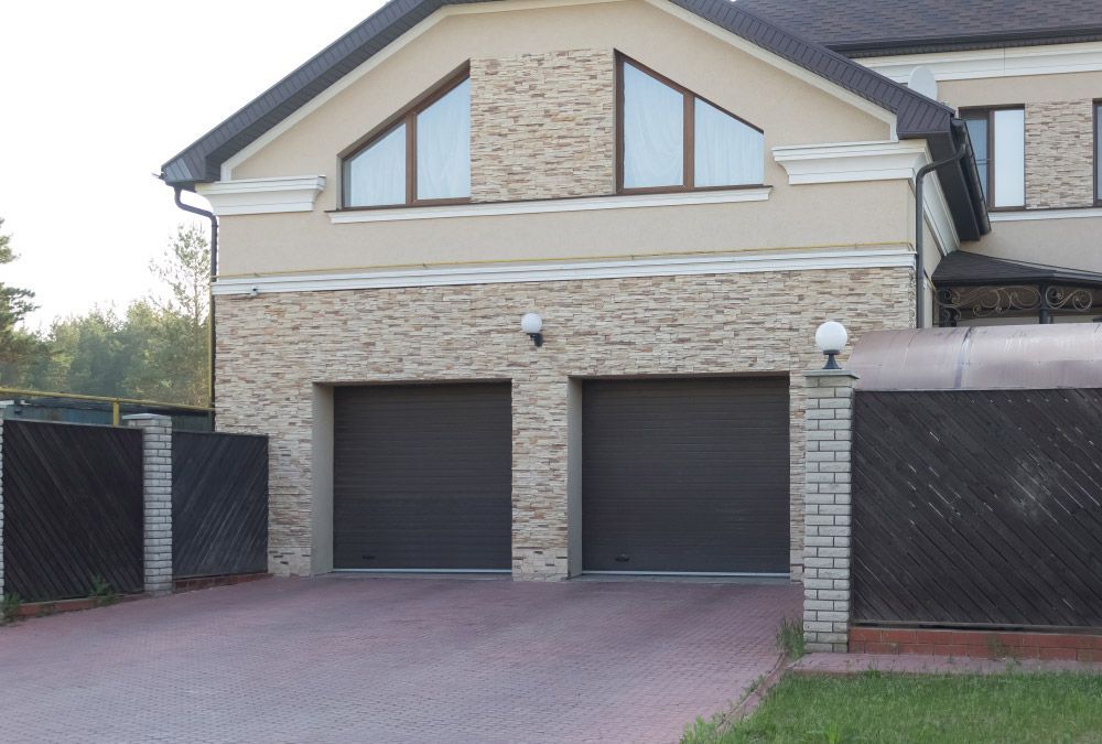 A Large House With Two Garage Doors and a Driveway — Hastings Garage Door Services in Port Macquarie