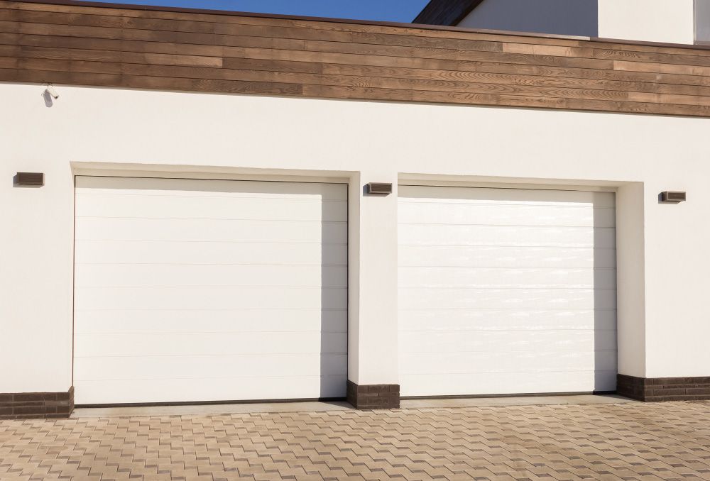 There Are Two White Garage Doors on the Side of a House — Hastings Garage Door Services in Port Macquarie