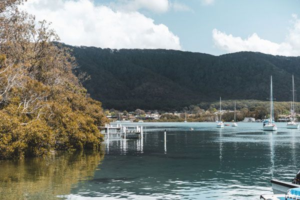 A Body of Water With Boats in It and Mountains in the Background — Hastings Garage Door Services in Camden Haven
