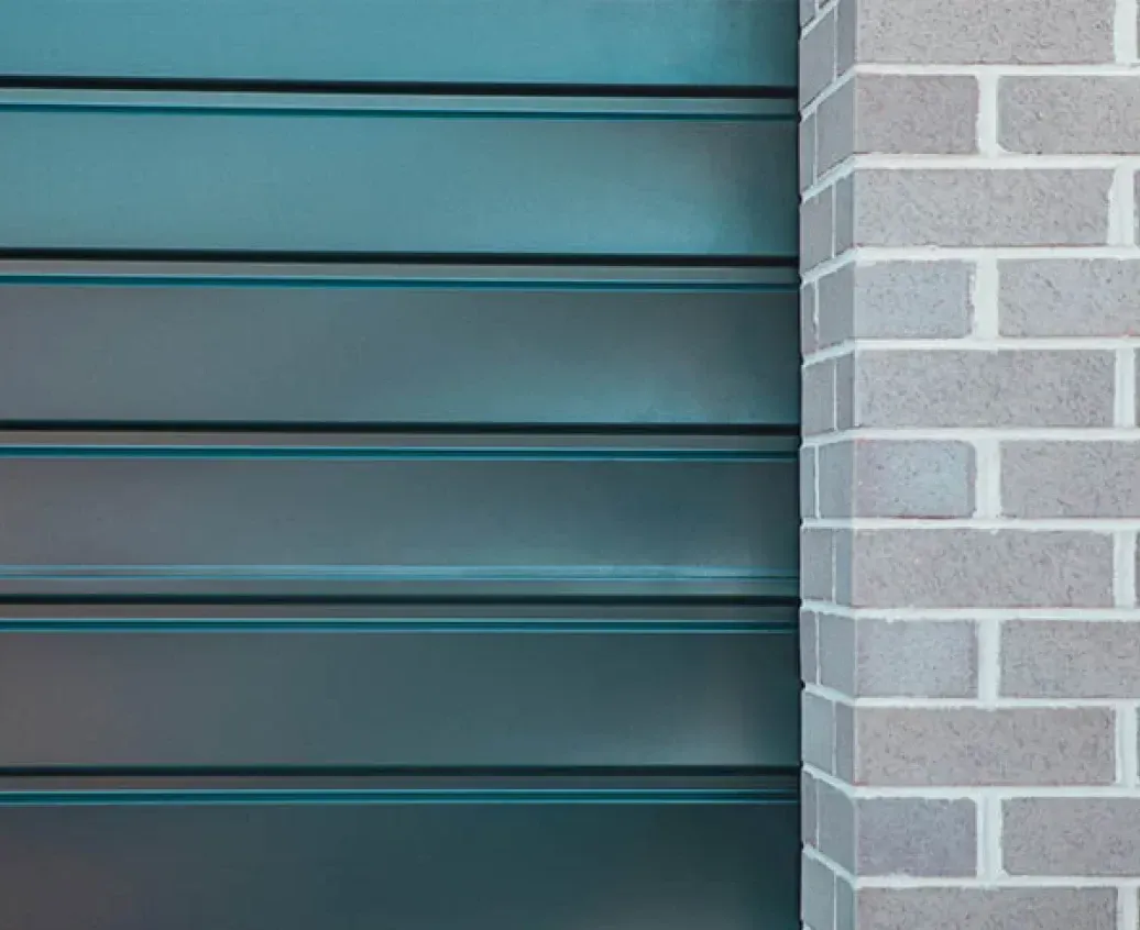 A Close Up of a Brick Wall With a Blue Door in the Background — Hastings Garage Door Services in Port Macquarie