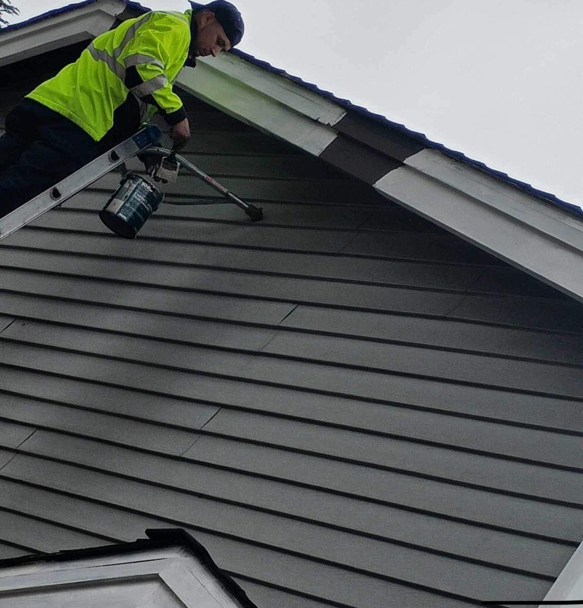 Man On A Ladder Painting Gutter — Lacey, WA — Seamless Gutters Troy Services LL