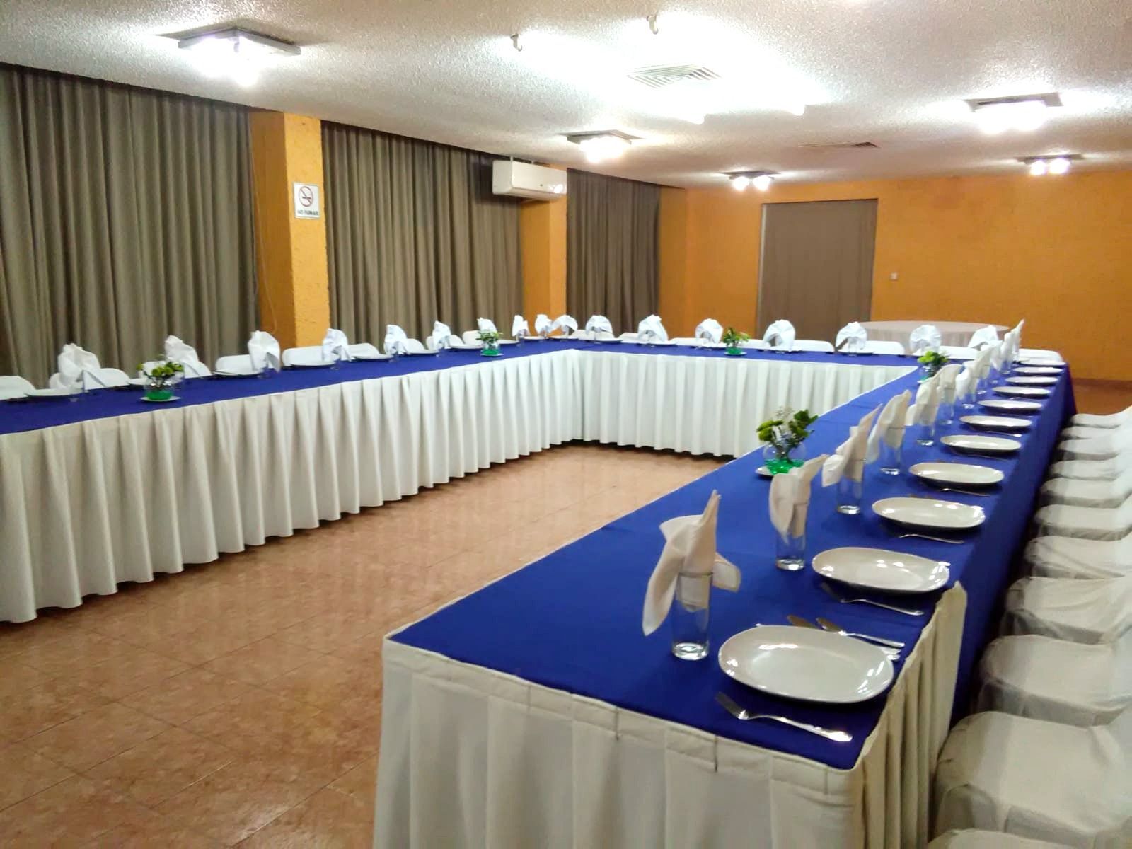Una mesa larga con platos y servilletas encima en el HOTEL DE CUAUTLA.