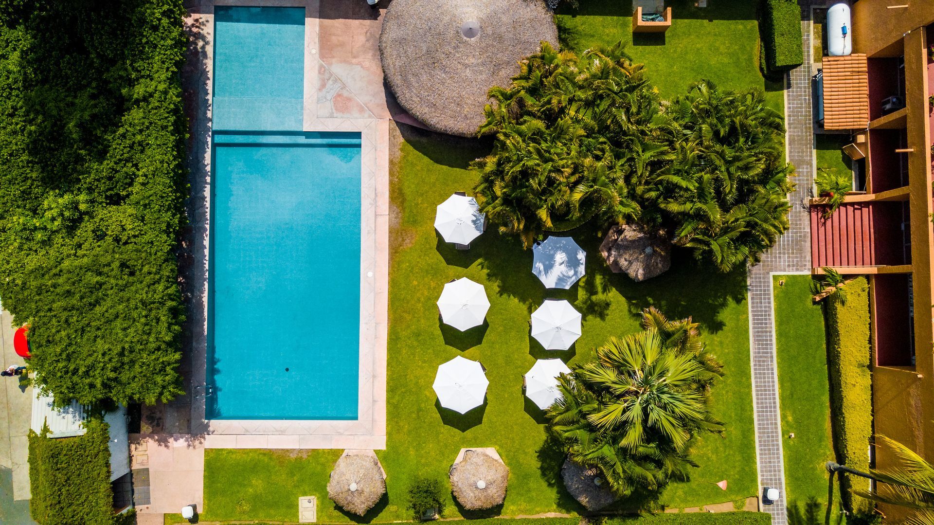 Una vista aérea de una piscina rodeada de sombrillas y árboles en HOTEL DE CUAUTLA,  Cuautla, Morelos