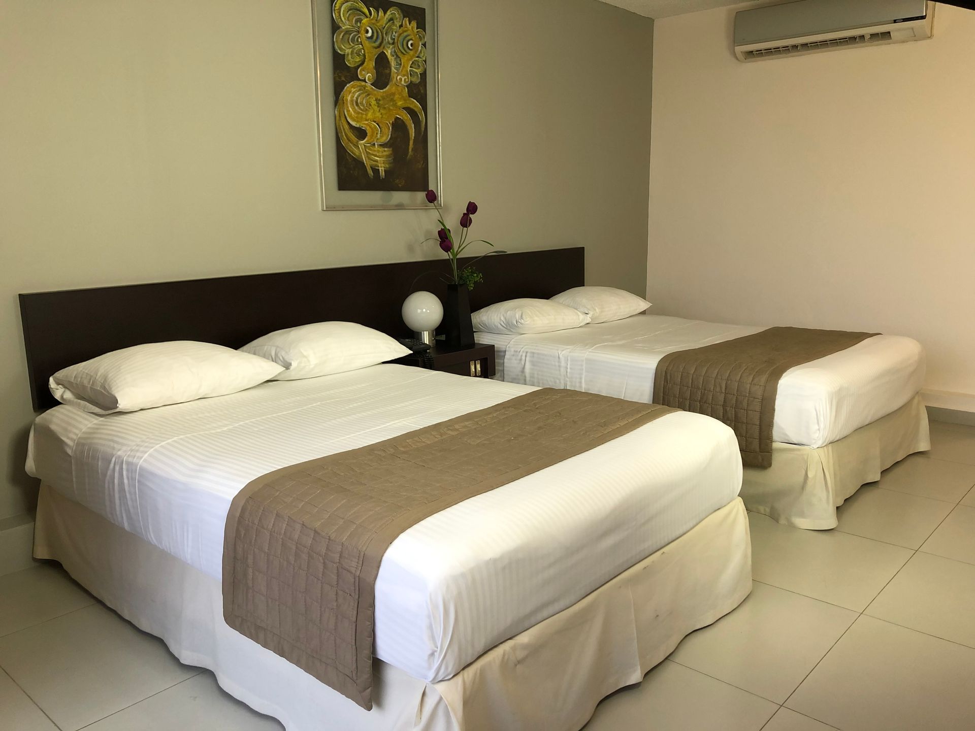 Una habitación de hotel con dos camas y un cuadro en la pared.