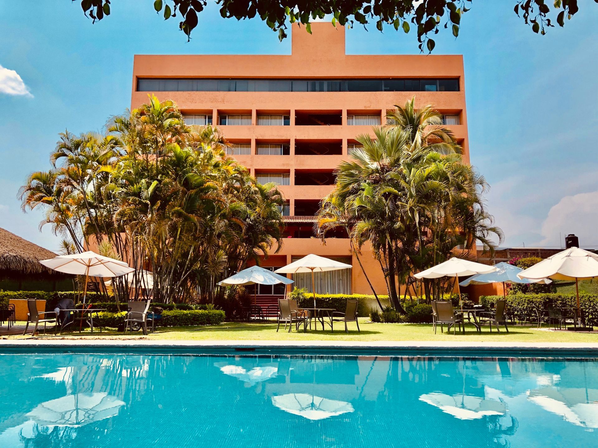 Un gran edificio con una piscina en frente.