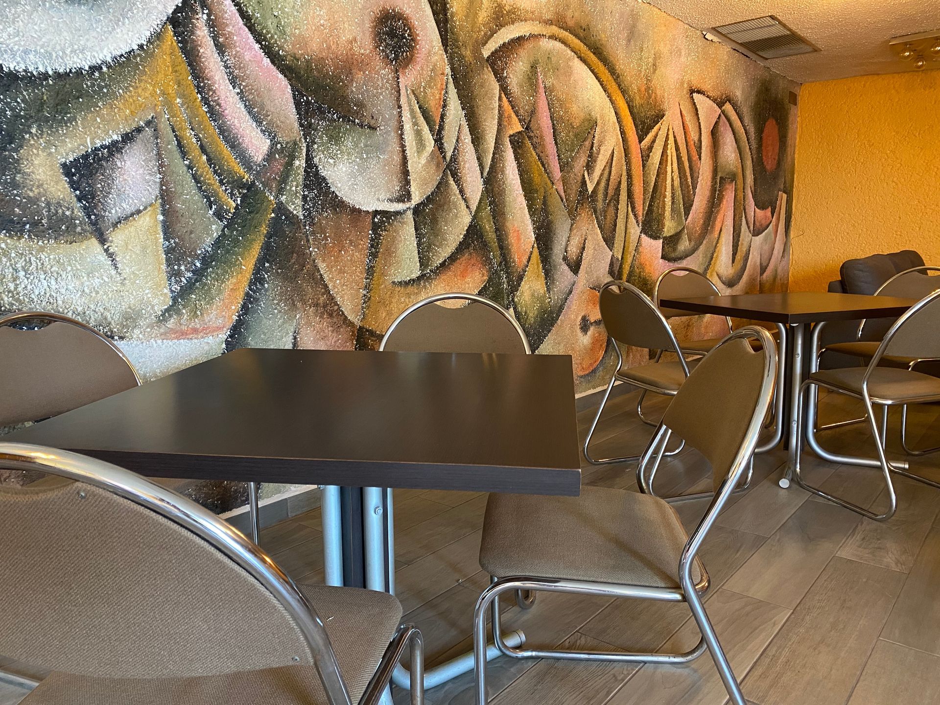 Restaurante HOTEL DE CUAUTLA con mesas y sillas y un mural en la pared.
