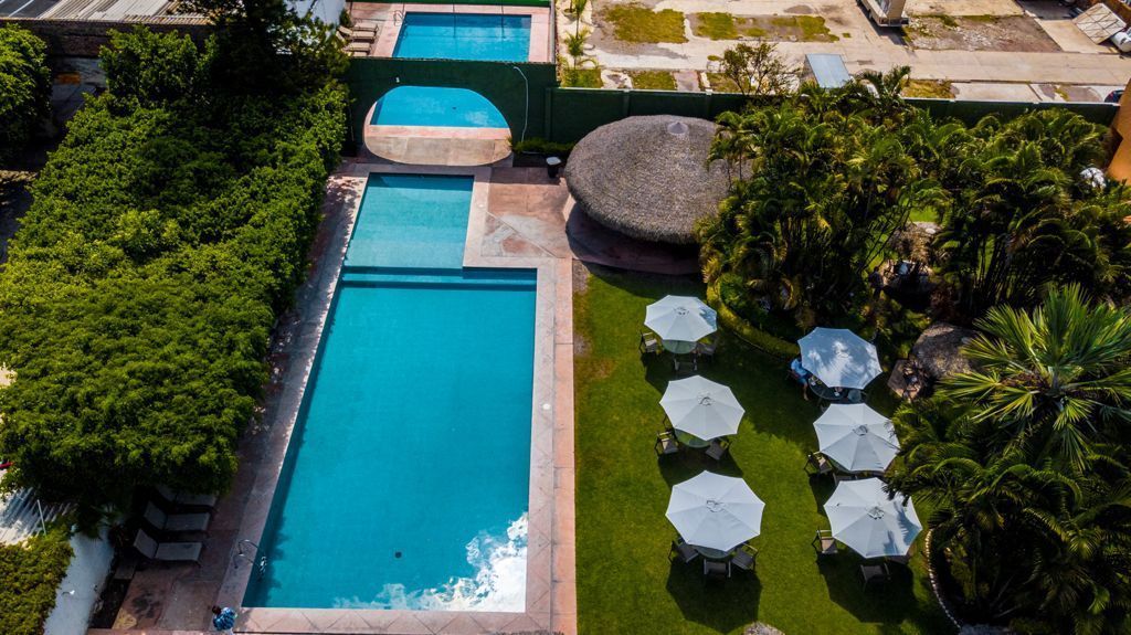Una vista aérea de una gran piscina rodeada de mesas y sombrillas en HOTEL DE CUAUTLA,  Cuautla, Morelos