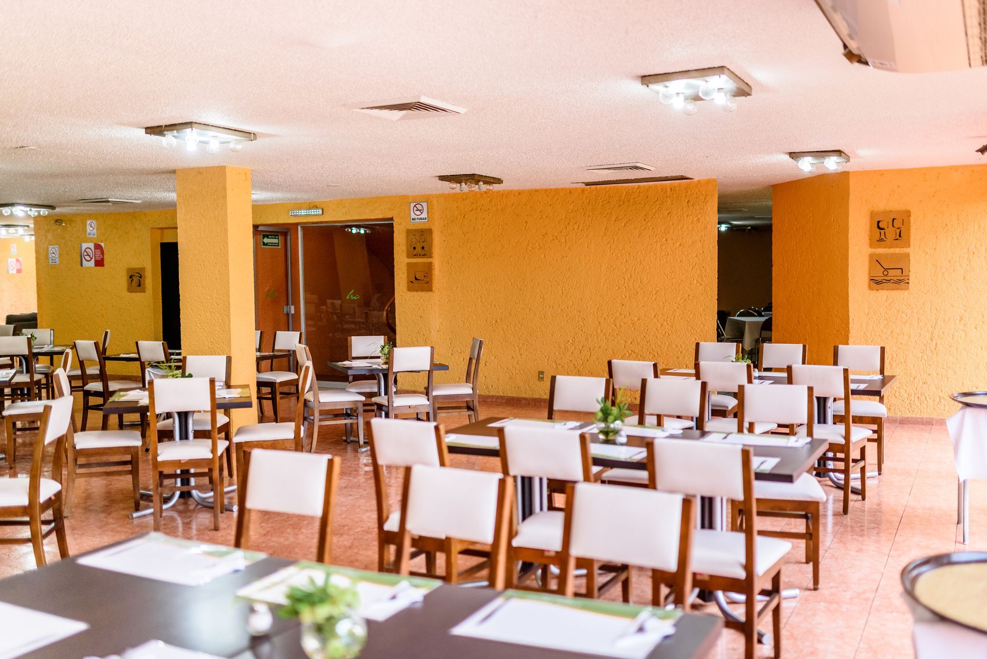 Un gran comedor con mesas y sillas del restaurante del HOTEL DE CUAUTLA.