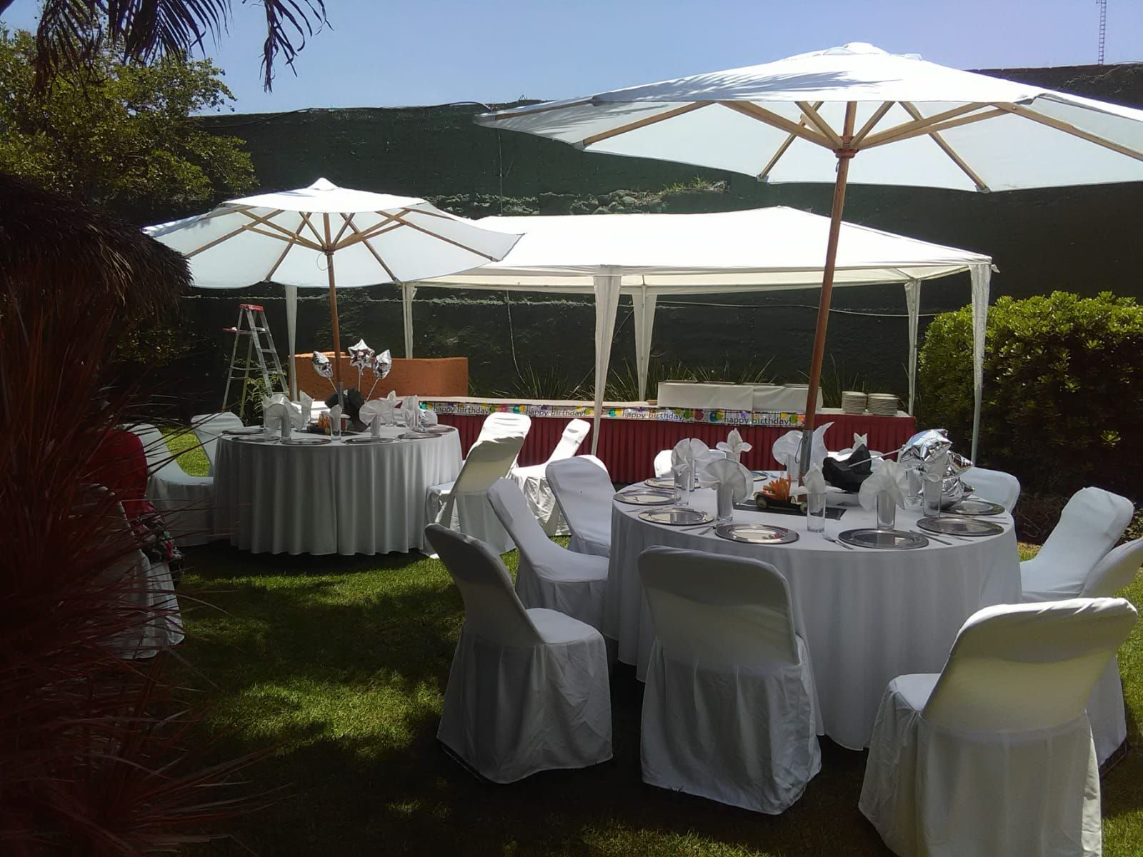 Se colocan mesas y sillas en el césped bajo sombrillas en el HOTEL DE CUAUTLA