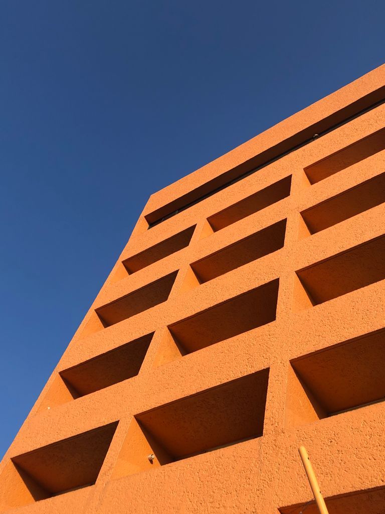 Edificio naranja  de HOTEL DE CUAUTLA con un cielo azul de fondo.