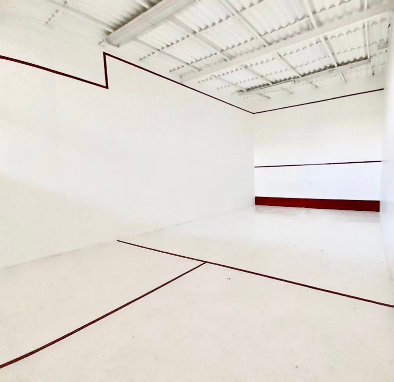 Una cancha de squash con paredes blancas y líneas rojas en HOTEL DE CUAUTLA